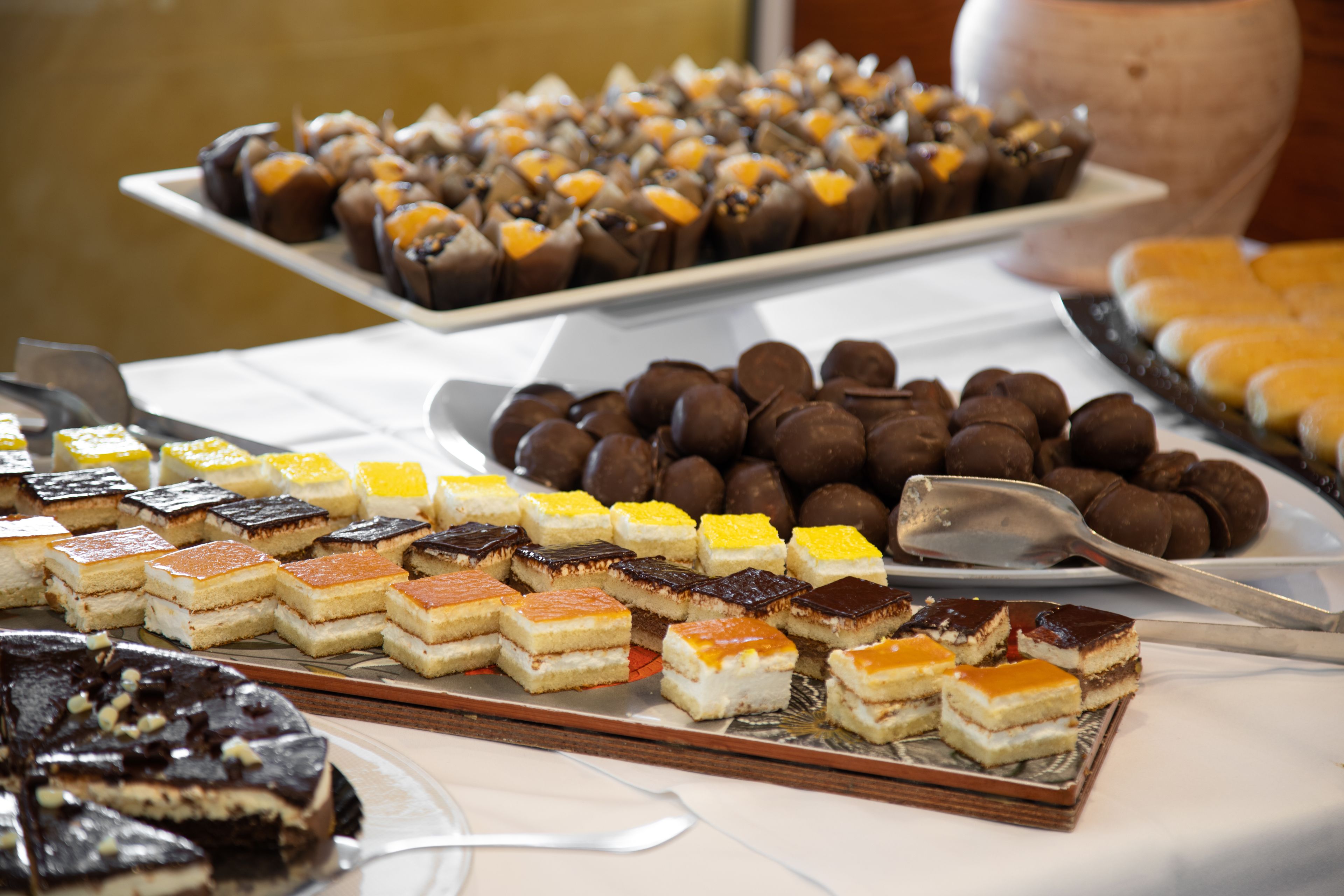 Een buffet met diverse desserts, waaronder taarten, brownies en gebak.