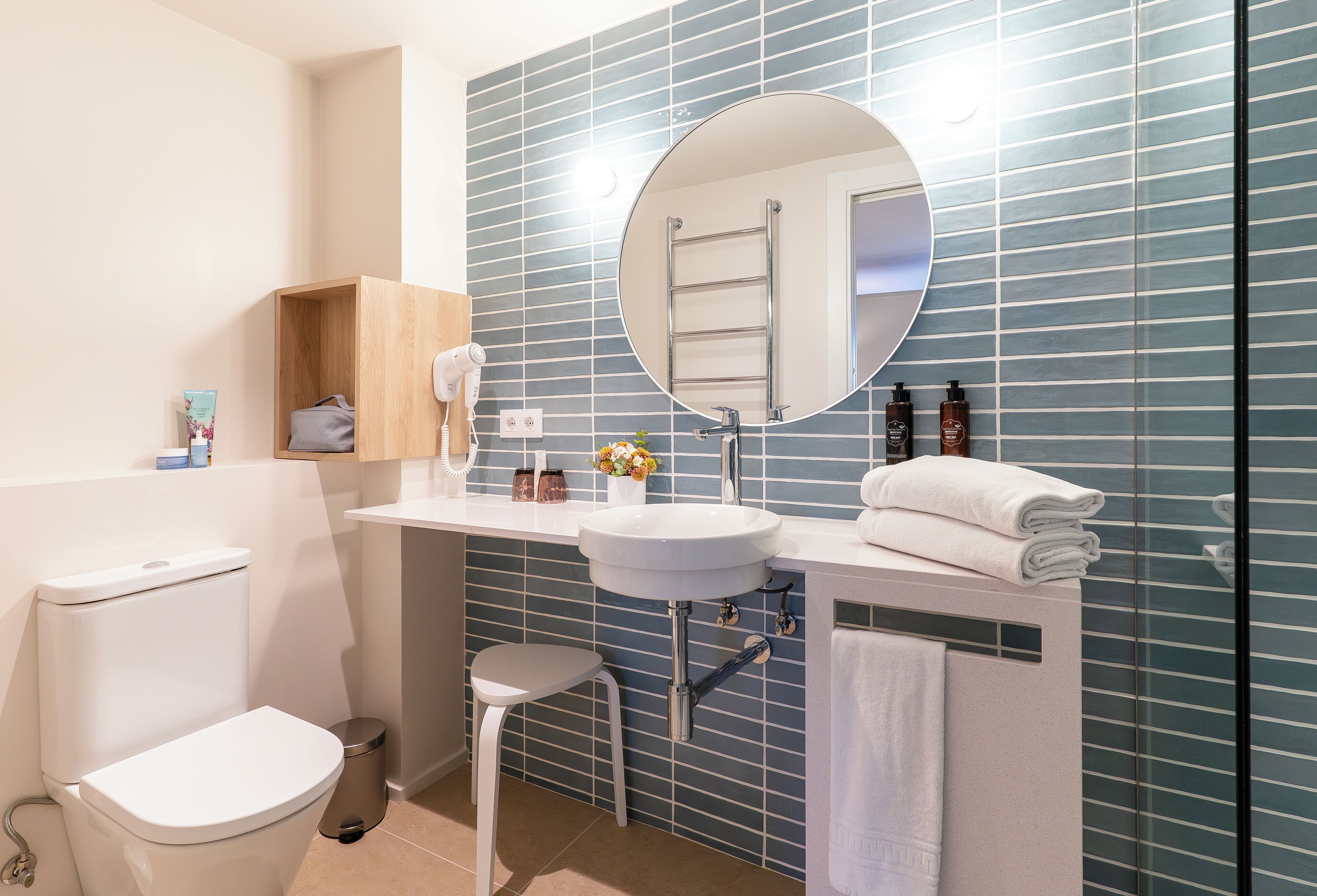 A modern bathroom with a toilet, sink, and mirror.