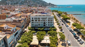 Hotel amb diverses plantes, un pati central amb seients a l'aire lliure i vistes al mar.