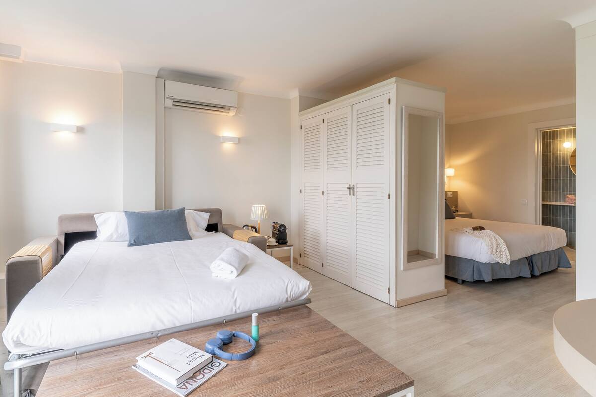 Une chambre d’hôtel comprenant un lit, une table de chevet, une lampe et une armoire.