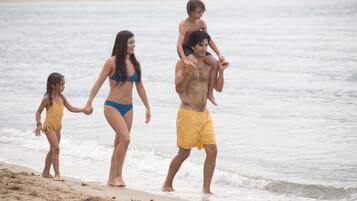 Escena de playa con gente caminando por la orilla.