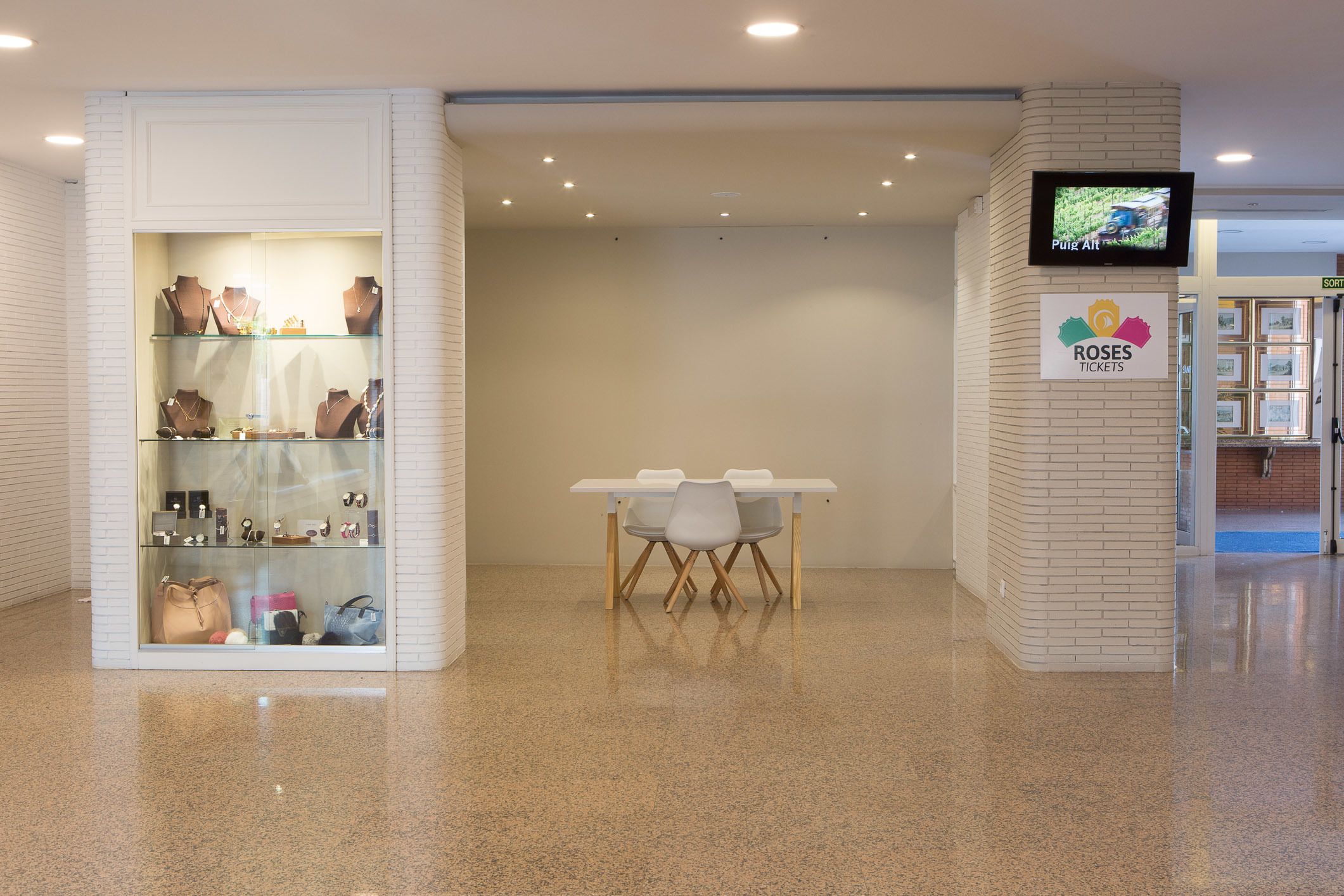 A jewelry display with a table and chairs in a clean, modern lobby area.
