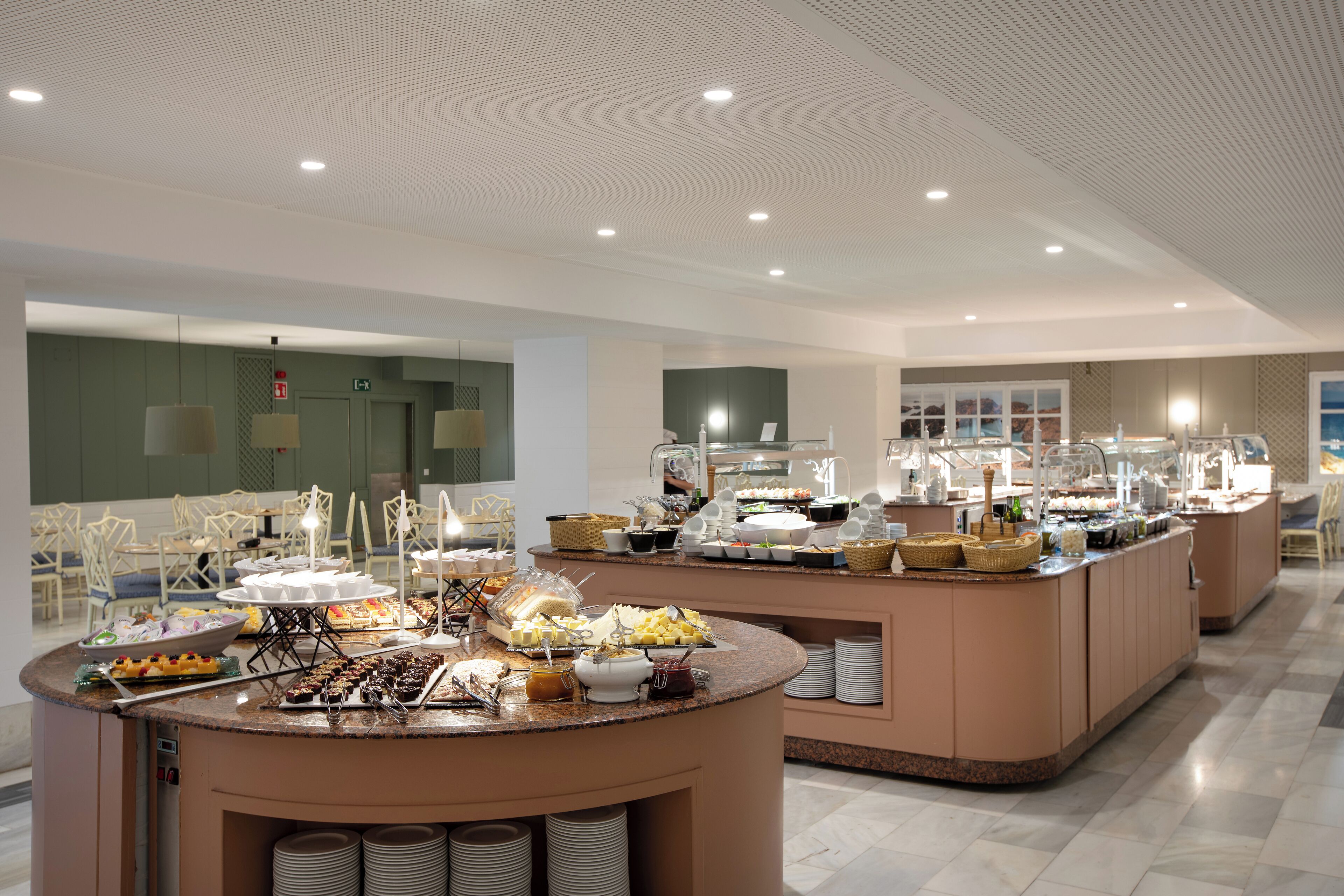 A buffet area with various food items and a seating area with chairs.