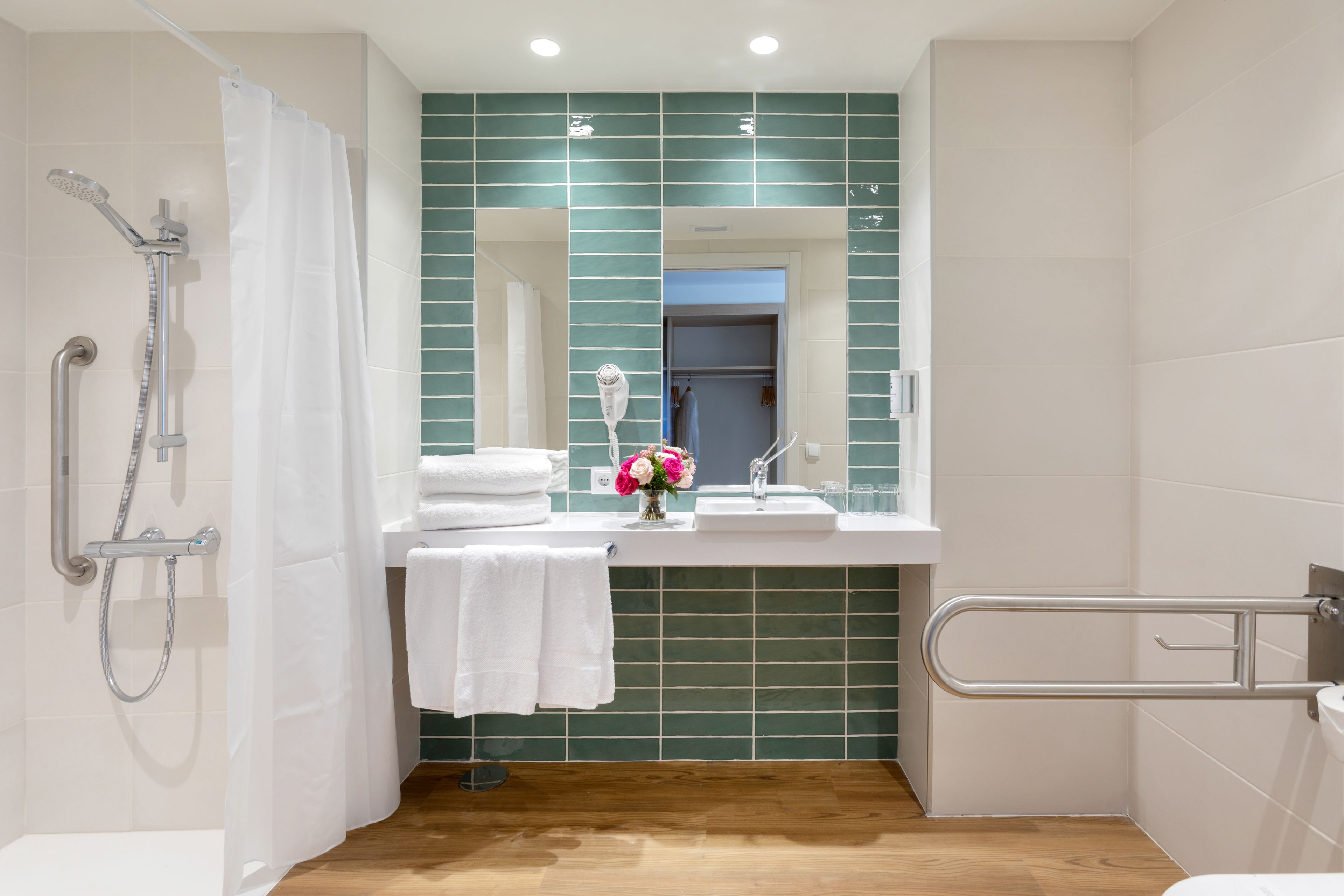 Ein modernes Badezimmer mit Dusche, Waschbecken und Spiegel.