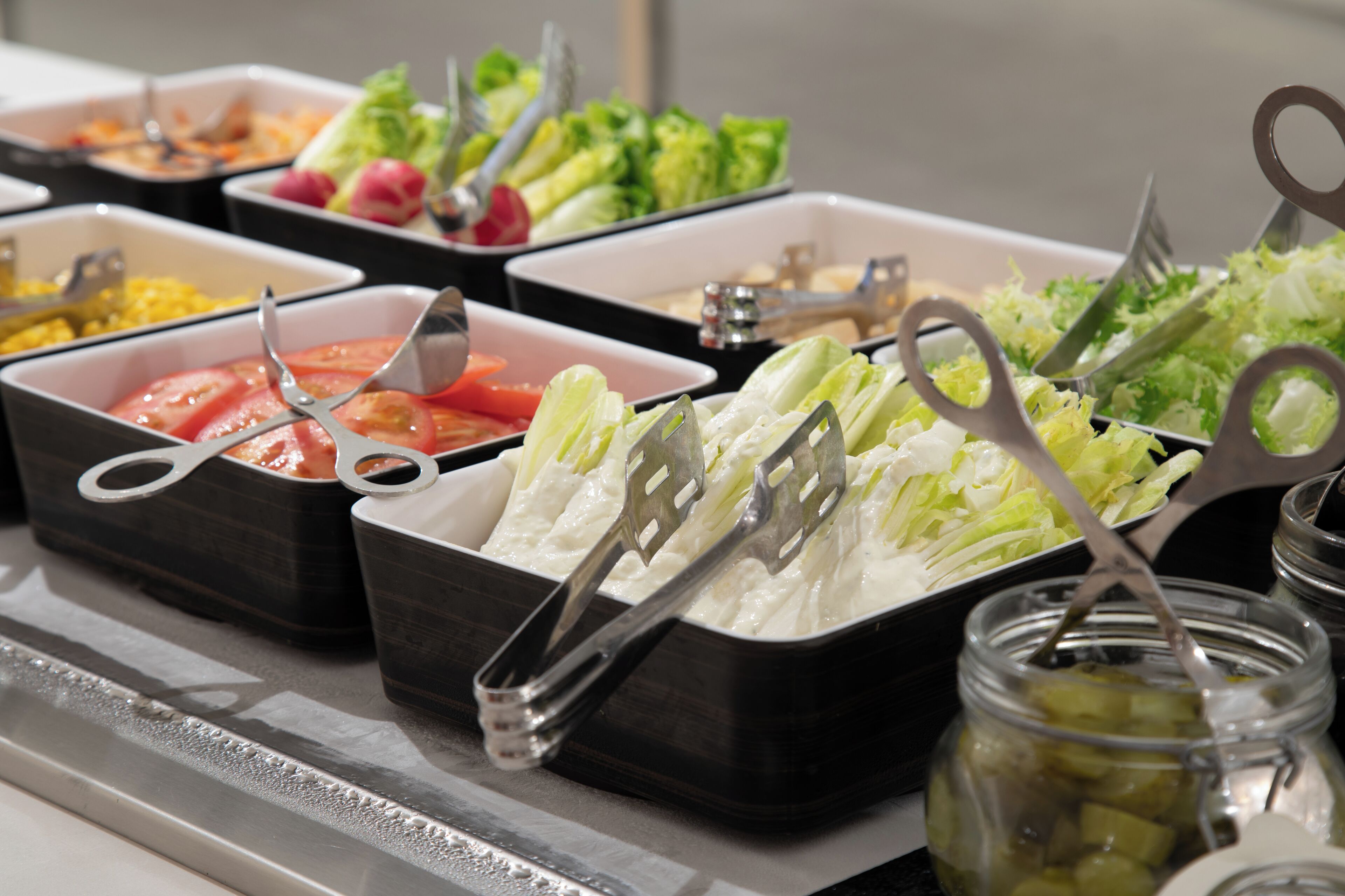 A buffet with various food options and serving utensils.