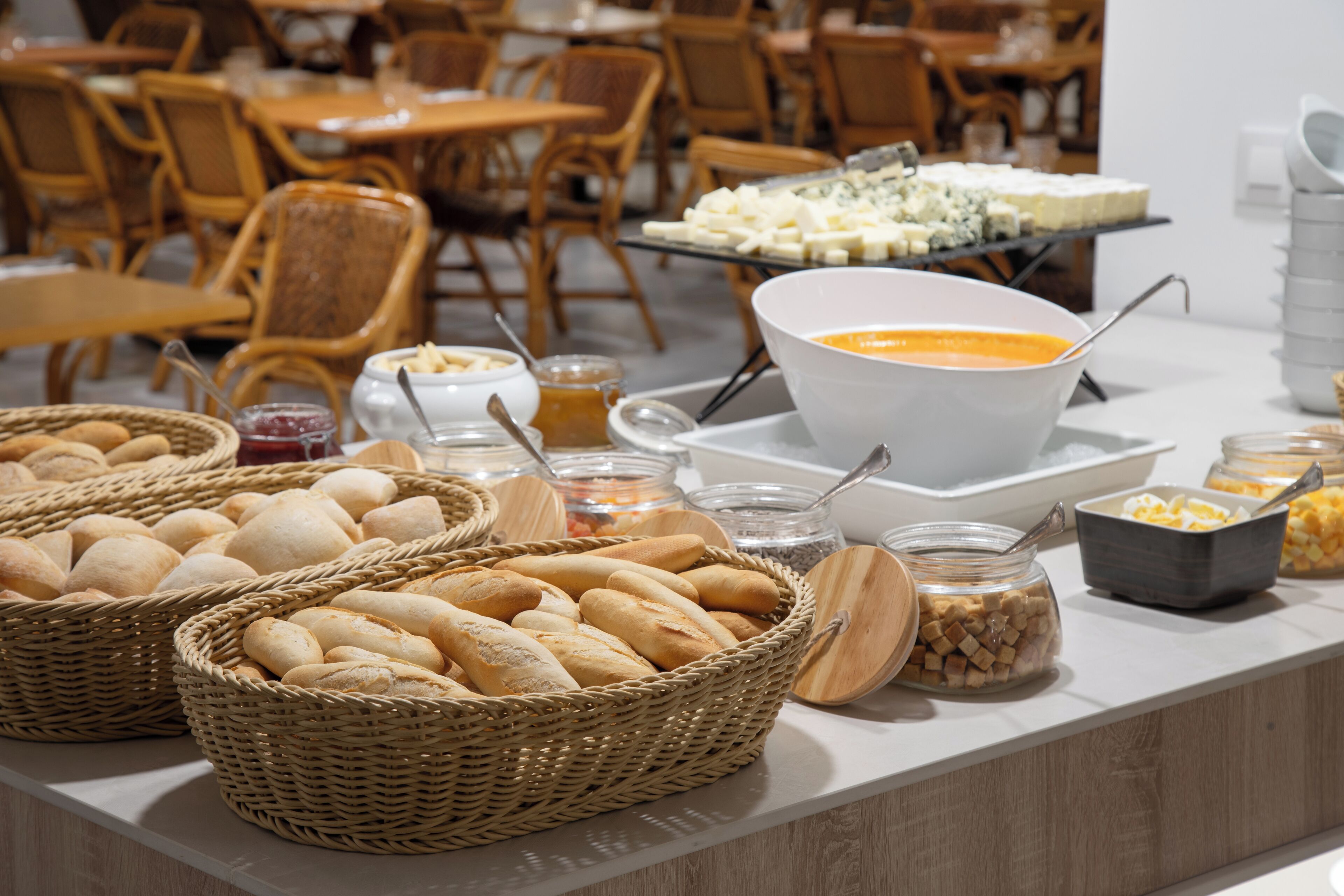 A buffet with various food items including bread, cheese, and condiments.