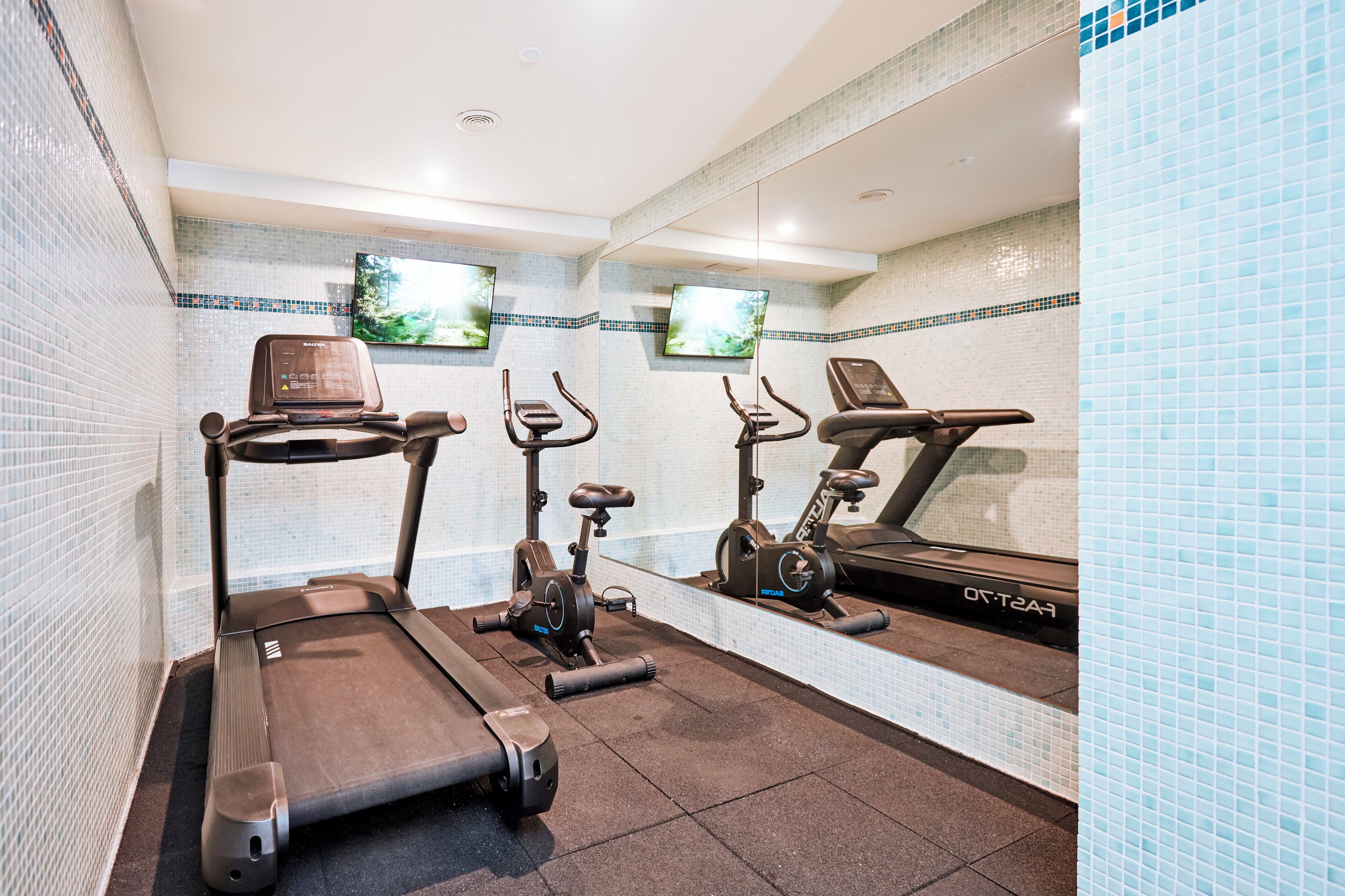 A gym with treadmills, stationary bikes, and an elliptical machine.