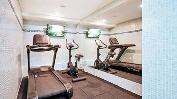 A gym with treadmills, stationary bikes, and an elliptical machine.