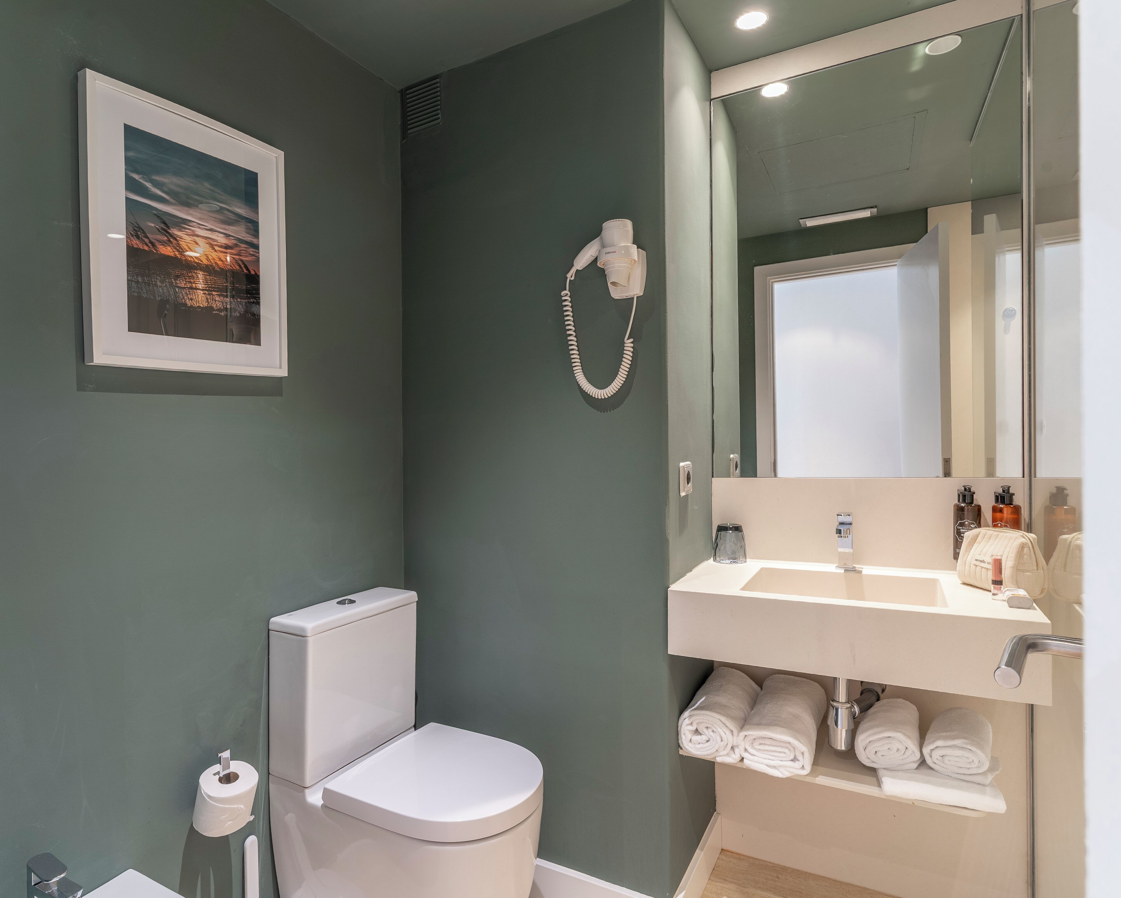 Un baño moderno con inodoro, lavamanos y ducha.