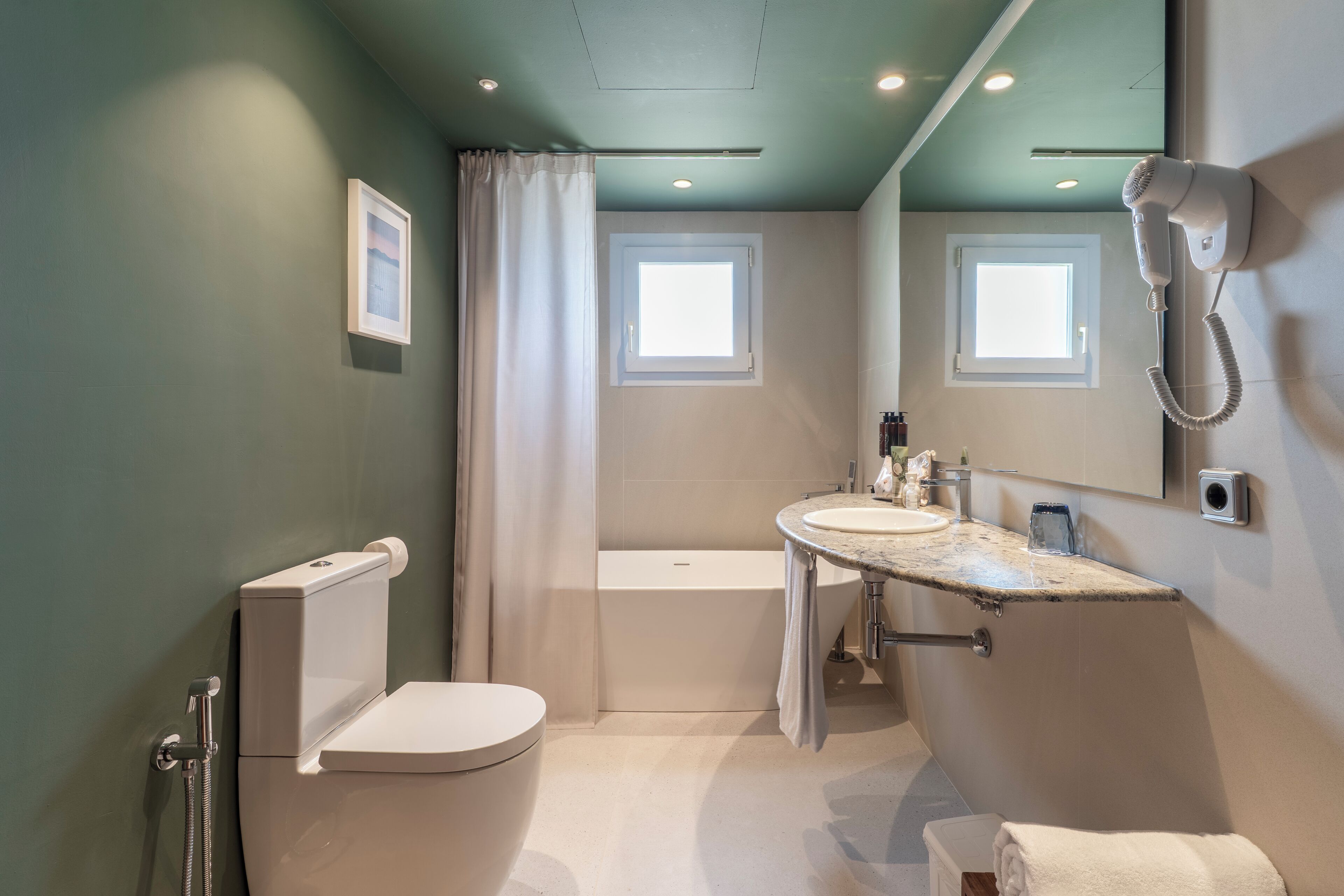 Un baño moderno con inodoro, lavabo y bañera.