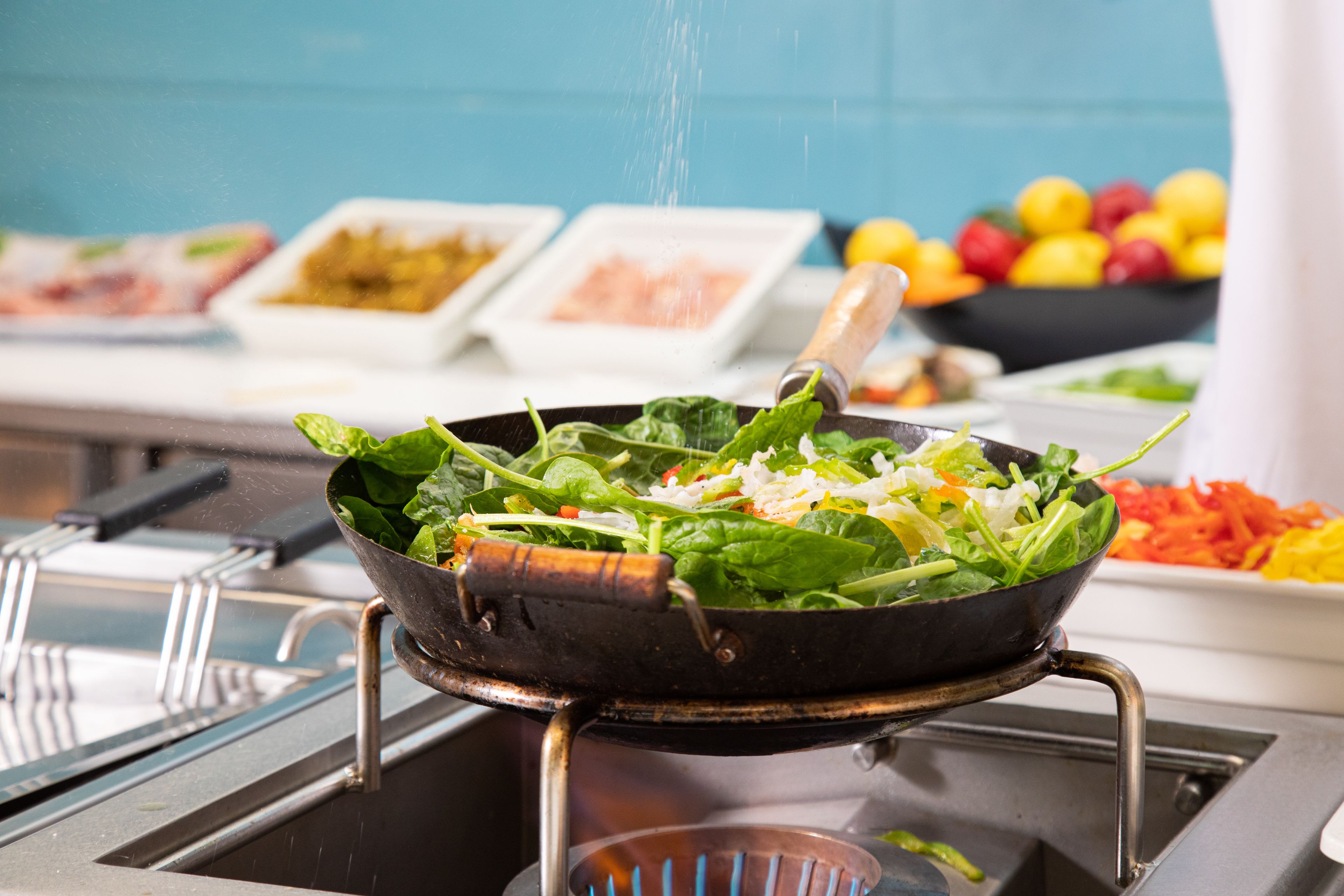 Un buffet proposant une variété de plats, notamment une salade présentée dans un plat et d’autres aliments disposés à l’arrière-plan.