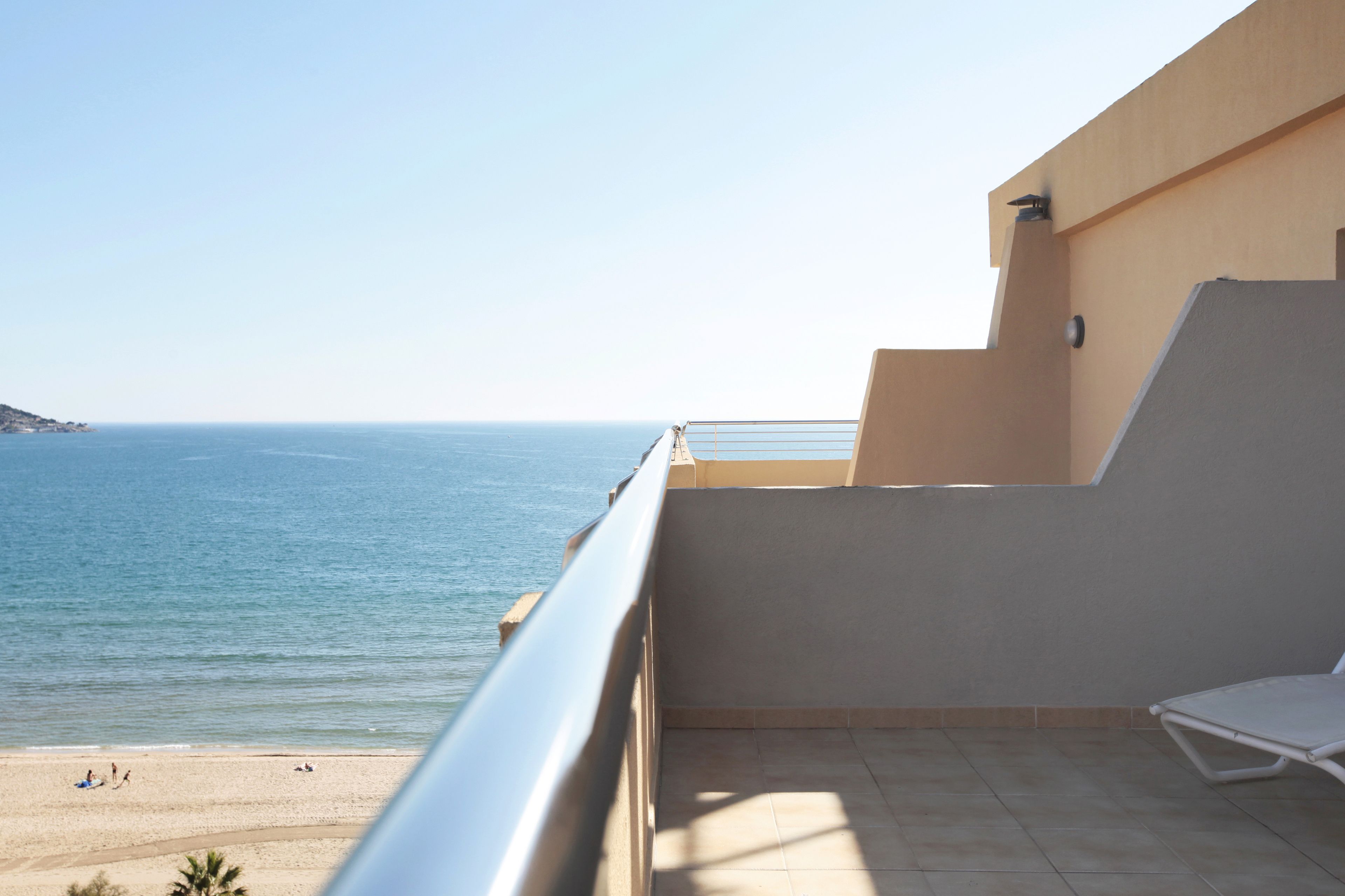 Un balcón con vista al mar y a la playa.