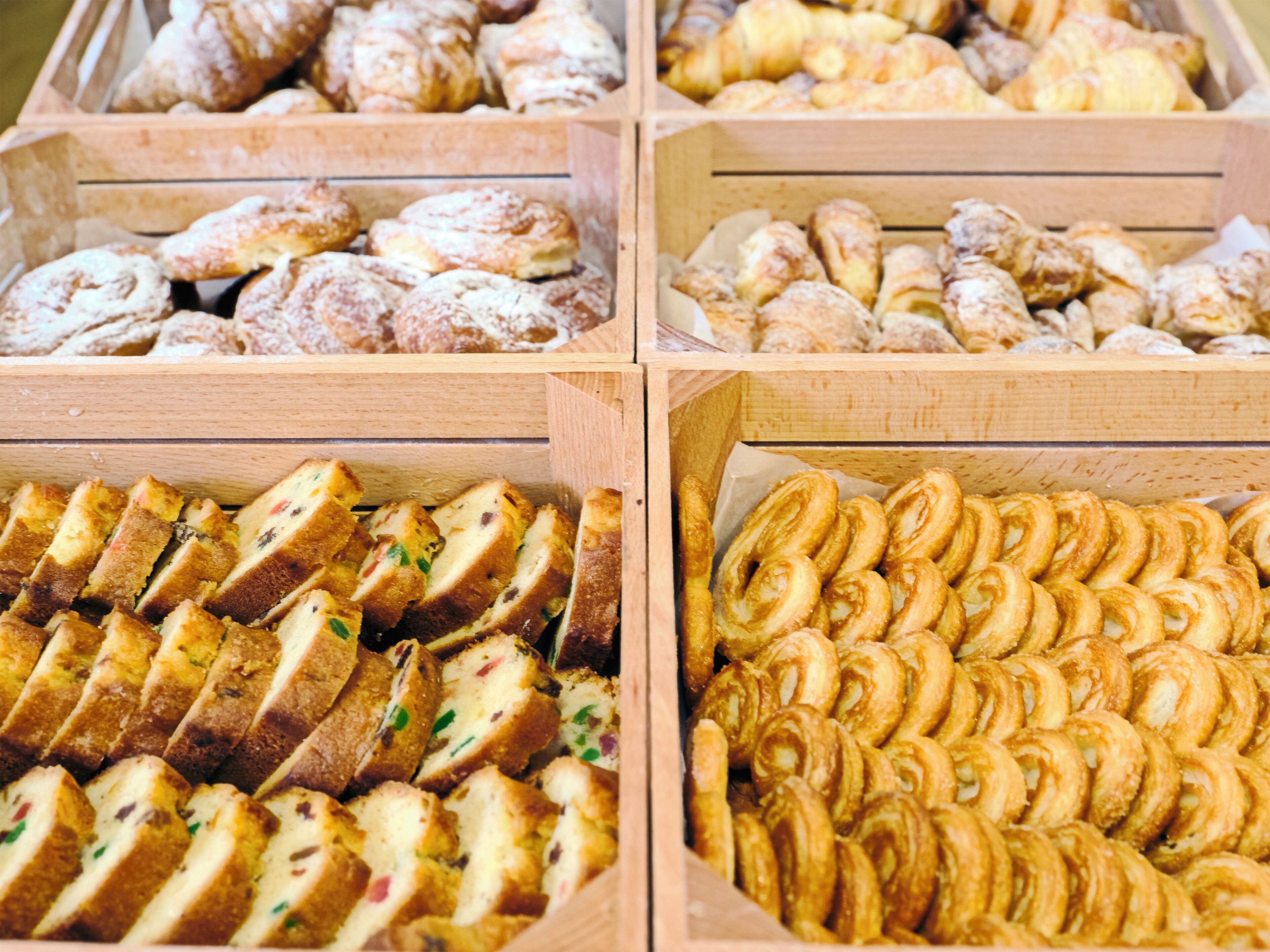 A display of various baked goods in wooden boxes.