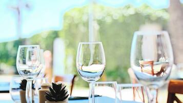 A table set for dining with wine glasses and a small potted plant.