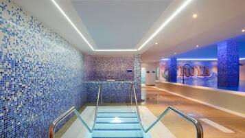 Un moderno vestíbulo de hotel con pared de azulejos, una recepción y una escalera.