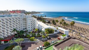 Un hôtel à plusieurs étages, doté d’un parking et offrant une vue sur la plage.