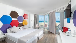 Une chambre d’hôtel moderne avec un grand lit, un bureau et une vue sur la mer.