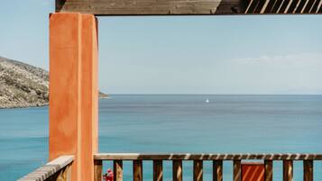 Un pontile di legno con vista sul mare e una vela all'orizzonte.