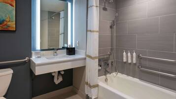 Een moderne badkamer met een bad, een douche, een wastafel en een toilet.