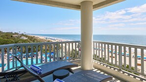 A balcony with a view of a beach and a pool area. - Hilton Beachfront Resort & Spa Hilton Head Island (Hilton Head Island)