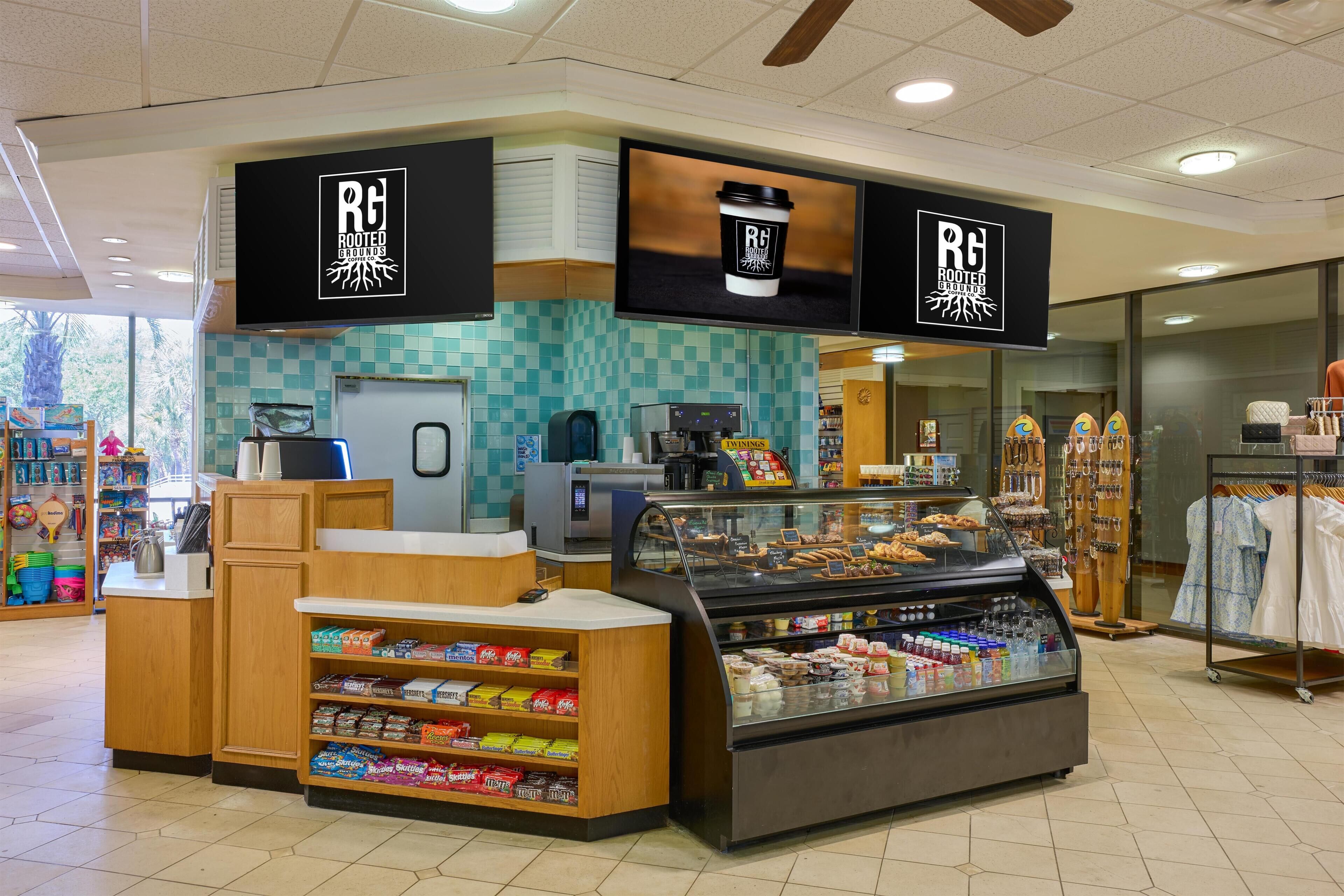 A coffee shop with a counter, display case, and branded signage.
