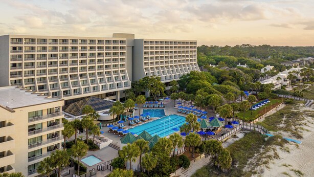 A hotel with multiple floors, a swimming pool, and a beach area. - Hilton Beachfront Resort & Spa Hilton Head Island (Hilton Head Island)