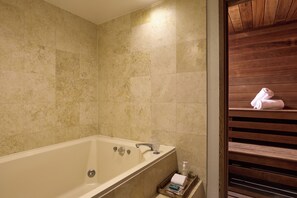 A bathroom with a bathtub, a wooden bench, and a towel rack.