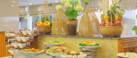 Un'area buffet con diversi cibi e piante ornamentali.