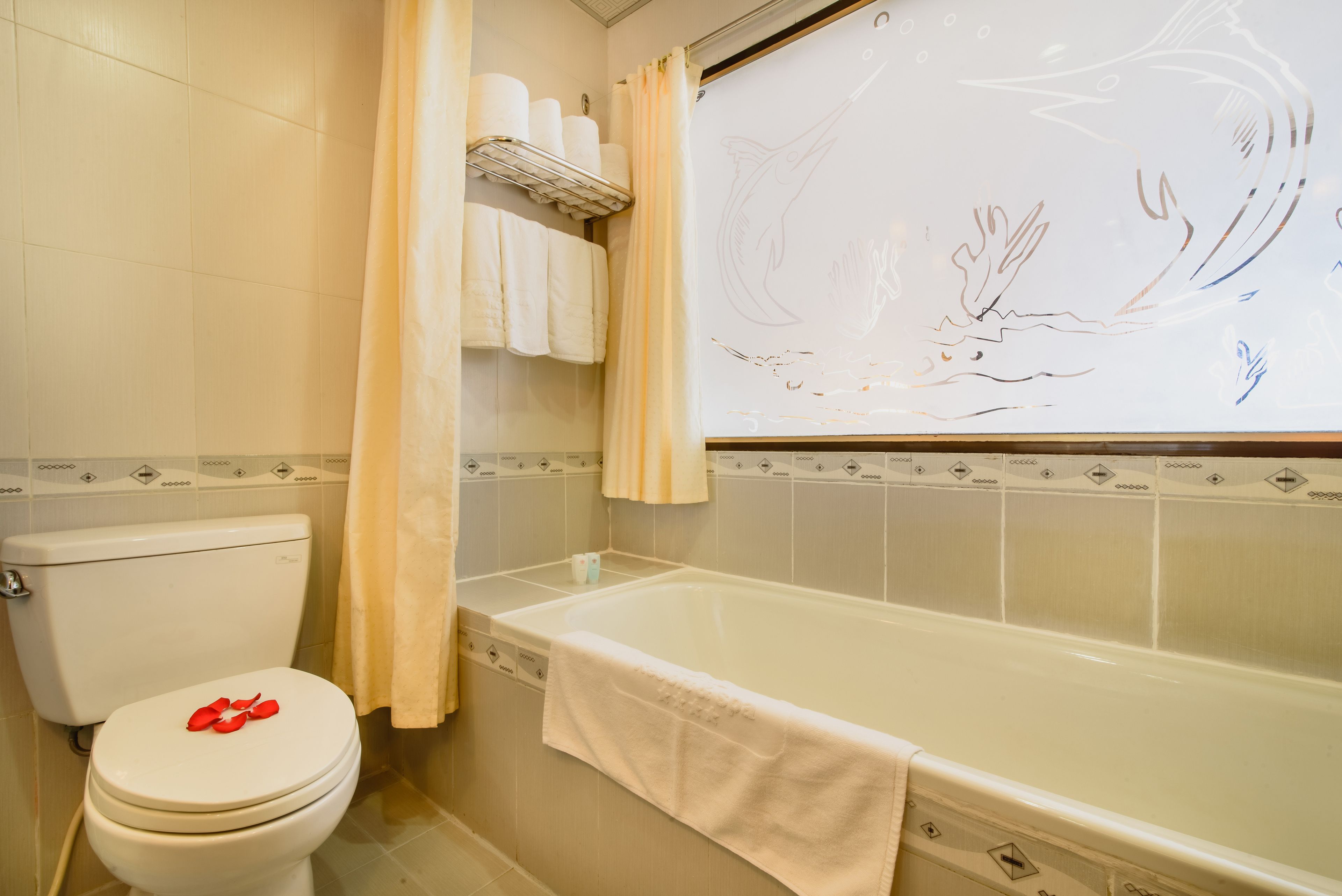A bathroom with a toilet, bathtub, and a shower curtain.