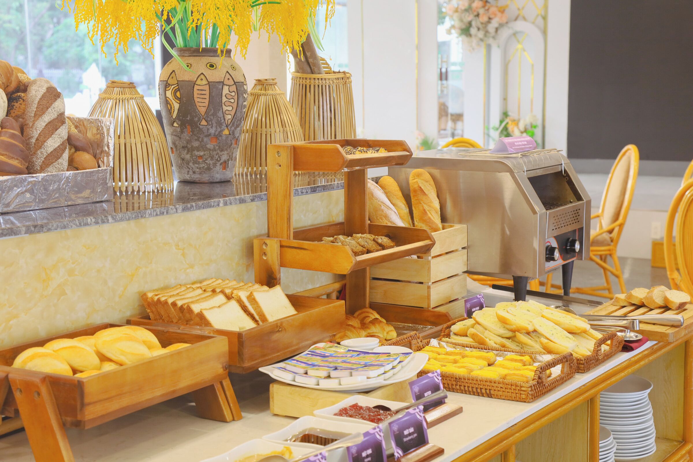 Un buffet proposant une variété de pains, de viennoiseries et une machine à café.