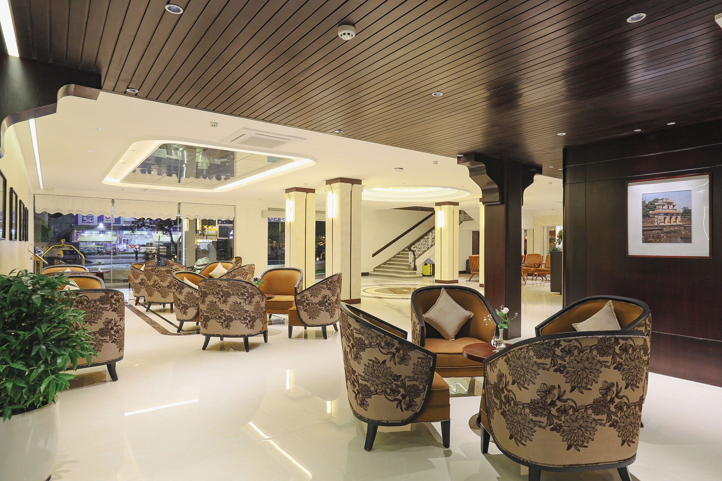 A spacious lobby with modern furniture, a staircase, and a large window.