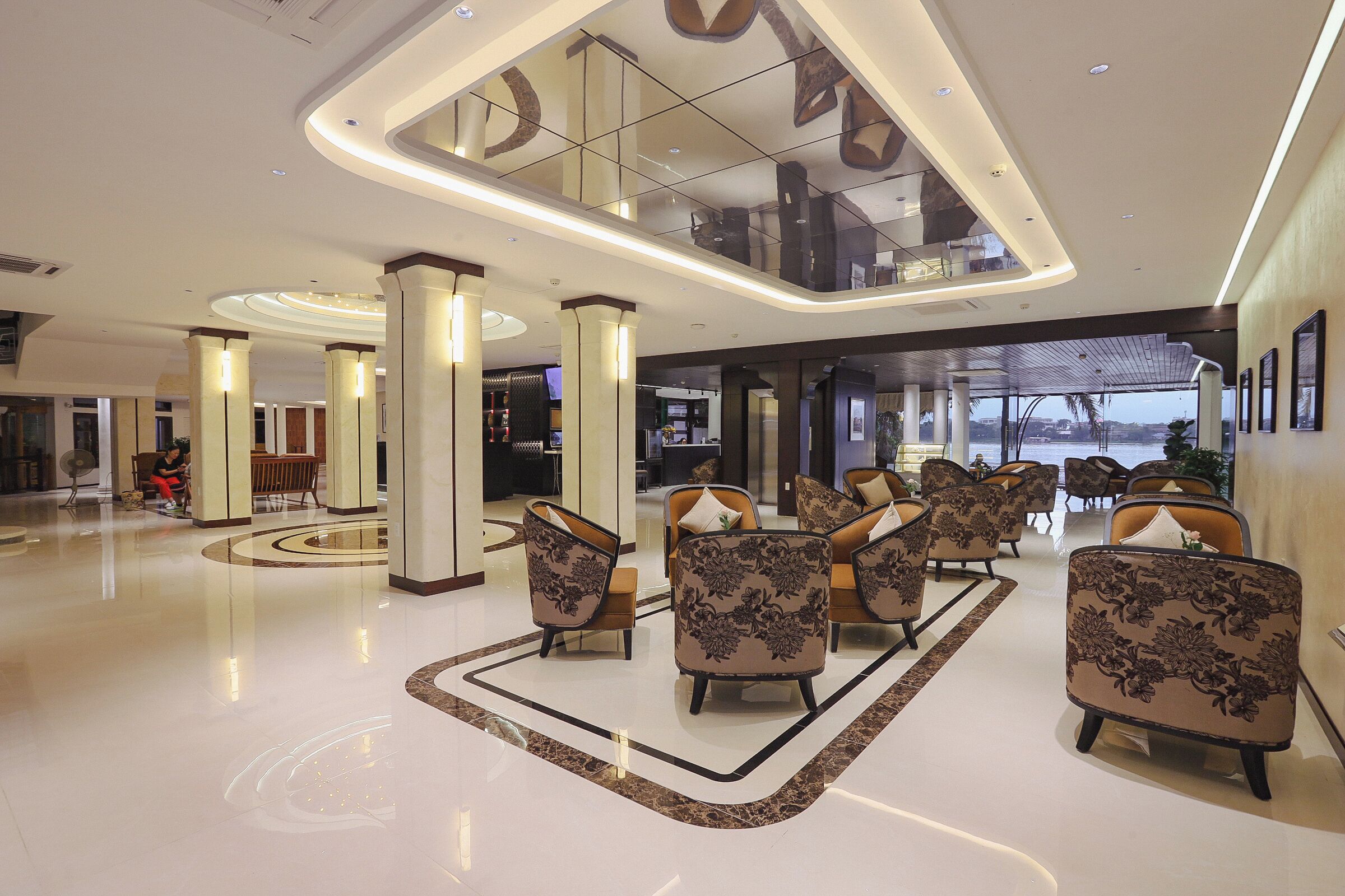 A spacious lobby with a high ceiling, modern furniture, and a central seating area.