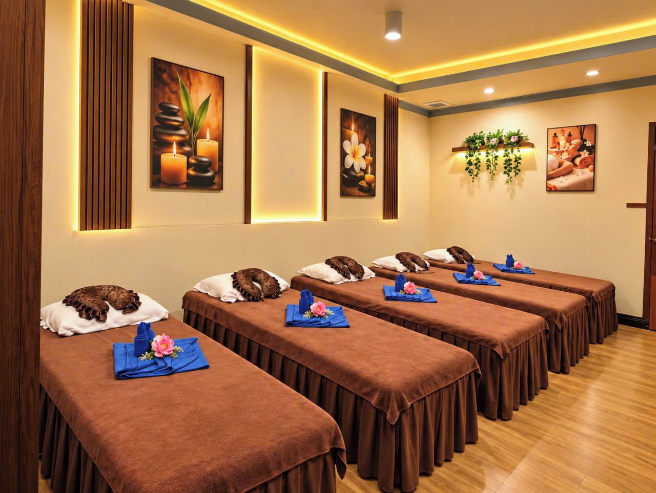 A room with multiple massage tables, each with a towel and a flower.