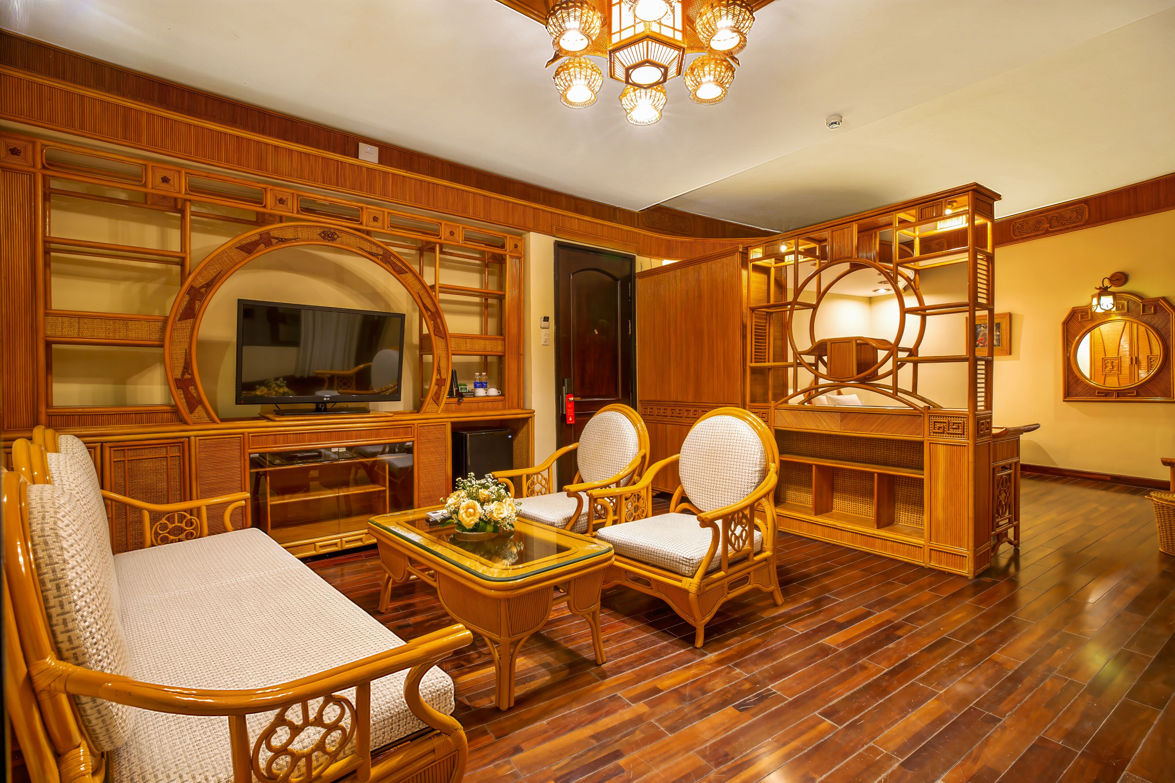 A traditional room with wooden furniture, a television, and a chandelier.