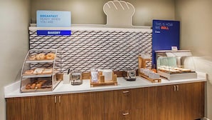 A breakfast buffet area with a bakery section and a display for breakfast items. - Holiday Inn Express Richmond Downtown by IHG (Richmond)