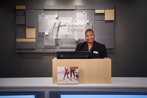 A reception desk with a Holiday Inn Express sign in the background. - Holiday Inn Express Richmond Downtown by IHG (Richmond)