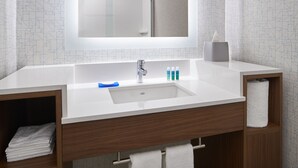 A modern bathroom with a white sink, wooden vanity, and a mirror above the sink. - Holiday Inn Express Richmond Downtown by IHG (Richmond)