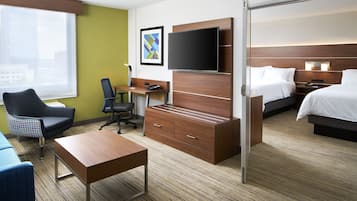 Una habitación de hotel con escritorio, silla, cama y televisor.