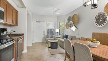 Eine moderne Küche mit Essbereich, inklusive Holztisch, Stühlen und Deckenventilator.