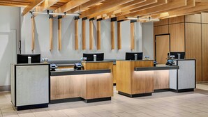 Un espace d’accueil doté de comptoirs de réception en bois, d’un design de plafond moderne et d’une esthétique épurée et minimaliste.