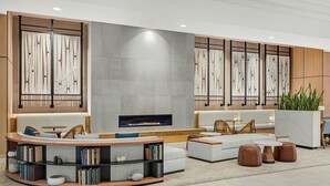 Un salon moderne doté d’une cheminée, de bibliothèques intégrées et de sièges confortables.