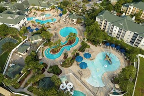 An aerial view of a resort with multiple swimming pools, sun loungers, and a large building with a green roof. - Sheraton Broadway Resort Villas (Myrtle Beach)