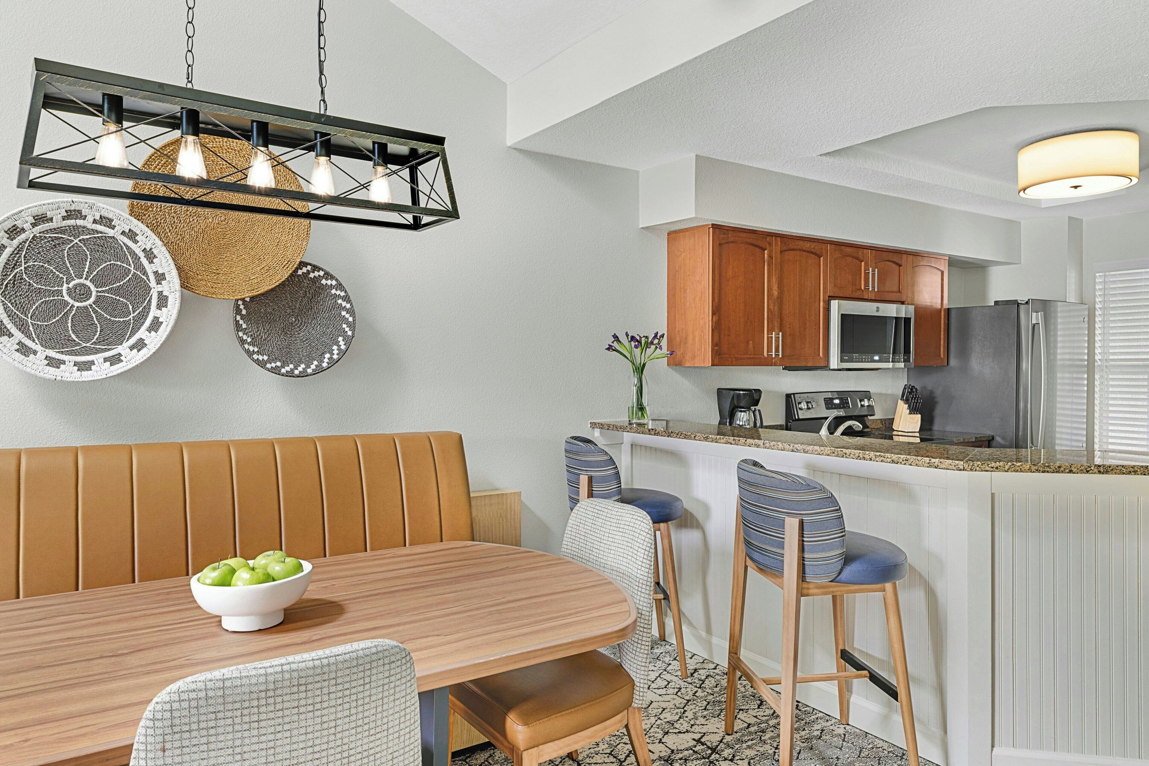 A modern kitchen with wooden cabinets, a stainless steel refrigerator, and a built-in microwave.