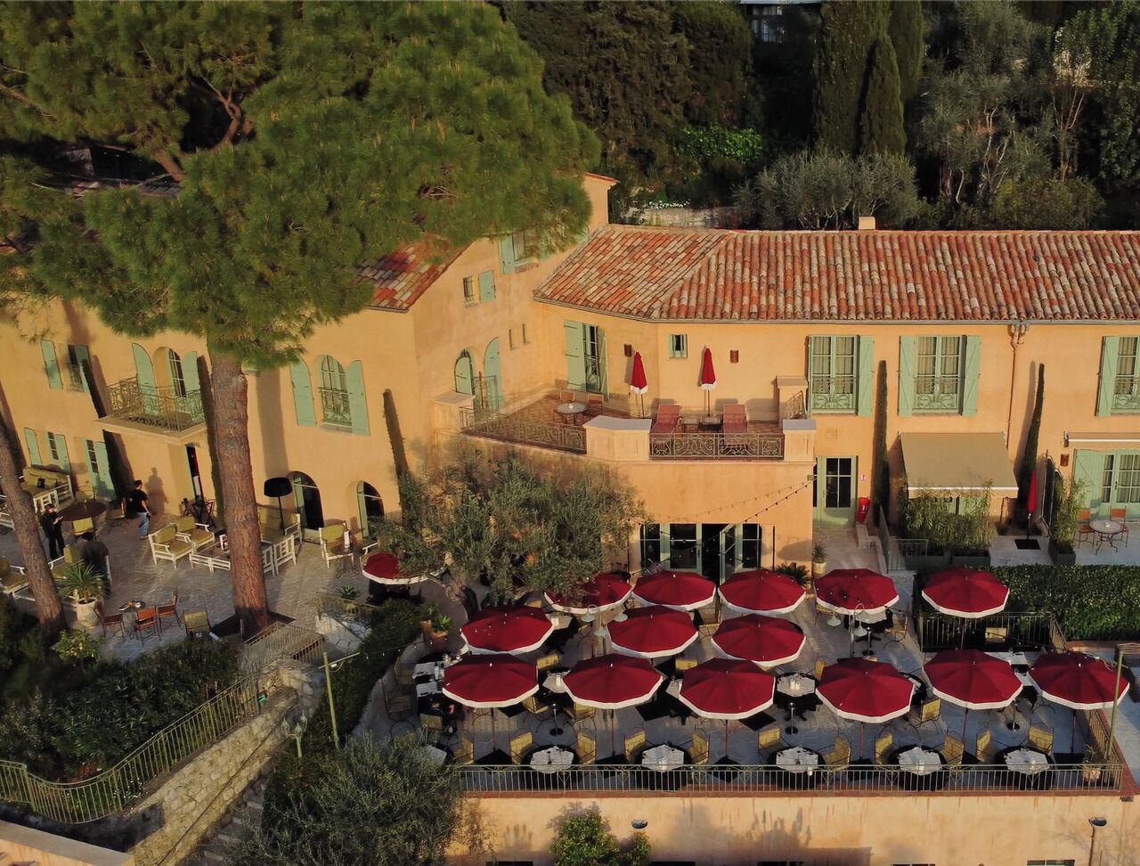 A courtyard with outdoor seating and a building with a tiled roof.