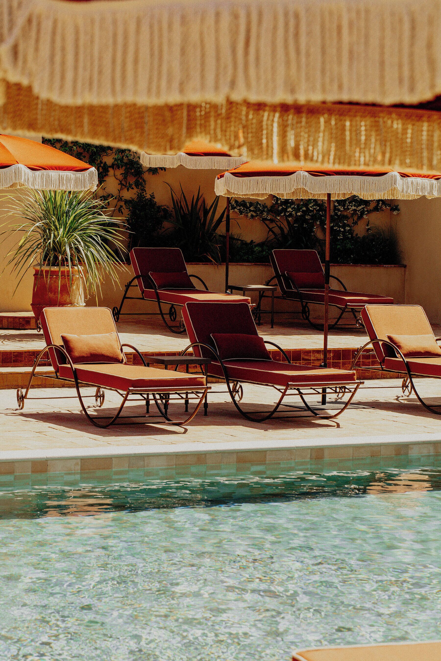 A poolside area with lounge chairs and umbrellas.