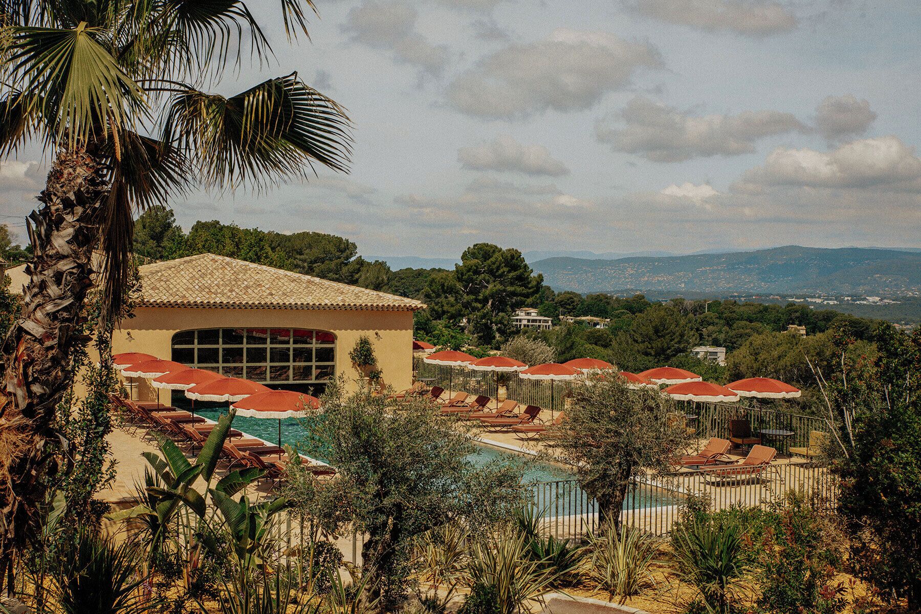 Un resort con piscina, zona de estar exterior y vistas del paisaje.