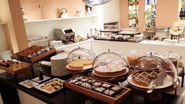 Un bufé con diversos postres y una estación de café.