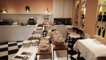 A buffet setup with various food items, a coffee station, and a selection of beverages.