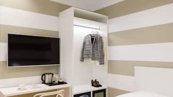A modern bedroom with a bed, a desk, a chair, a TV, and a wardrobe.
