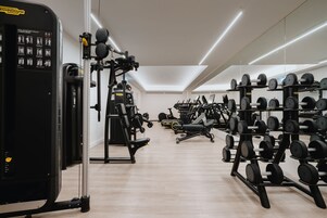 A gym with various exercise equipment, including weight racks and cardio machines.